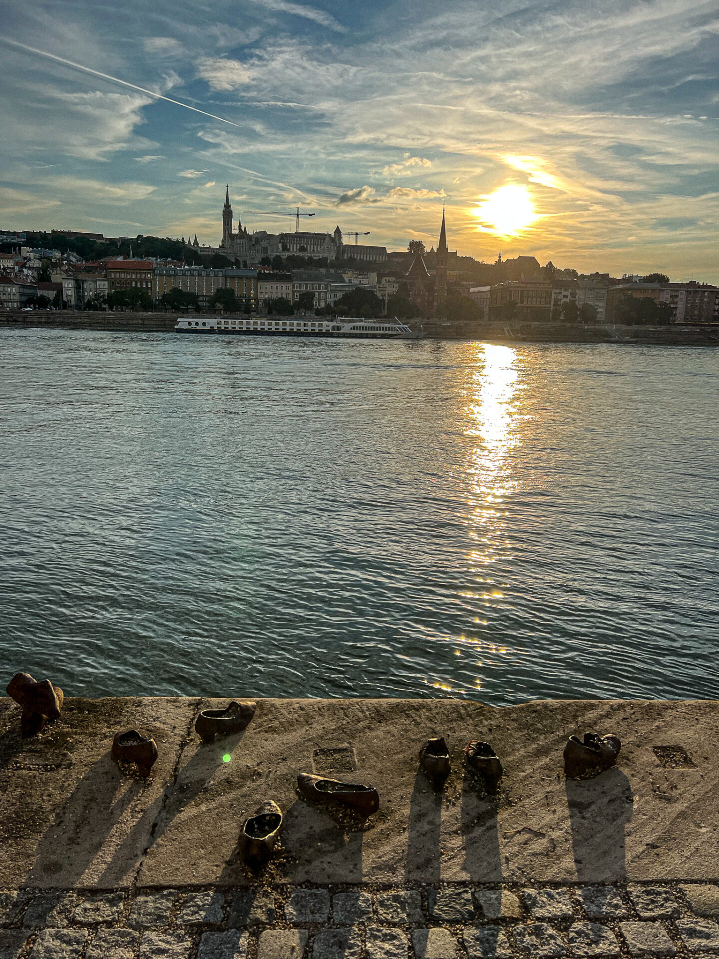 Visiting Budapest in two days: Shoes on the Danube Bank with the sun setting in the distance